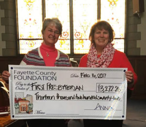 Pastor Judy and Carla Beard display asymbolic check from the Jane and Jerry Wilson Fund.