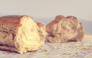 a loaf of white bread with sesame seeds, broken in half